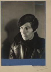 Alix Strachey with slicked hair, dressed in a leather jacket and black scarf
