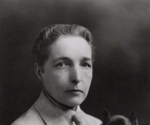 black and white photograph of Radclyffe Hall, sitting holding a dog